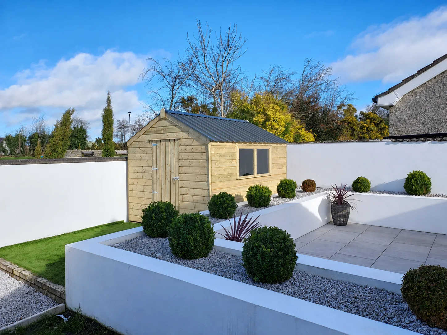 Timber garden shed within a landscaped garden