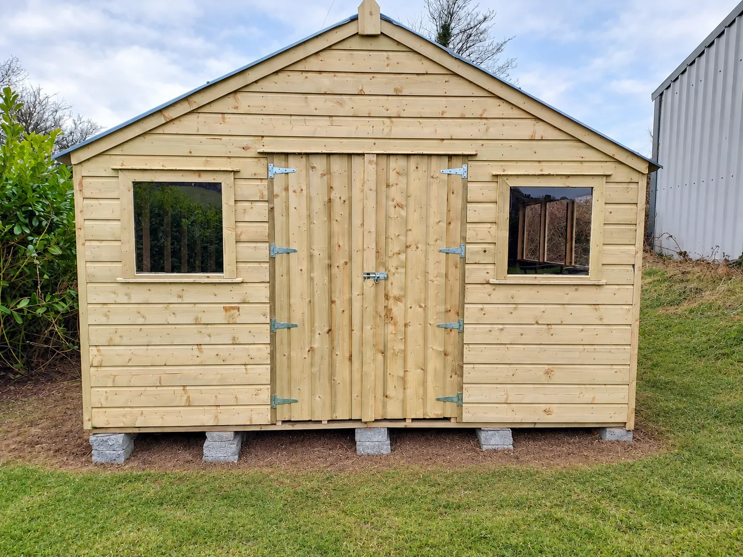 Large timber shed with double doors and windows